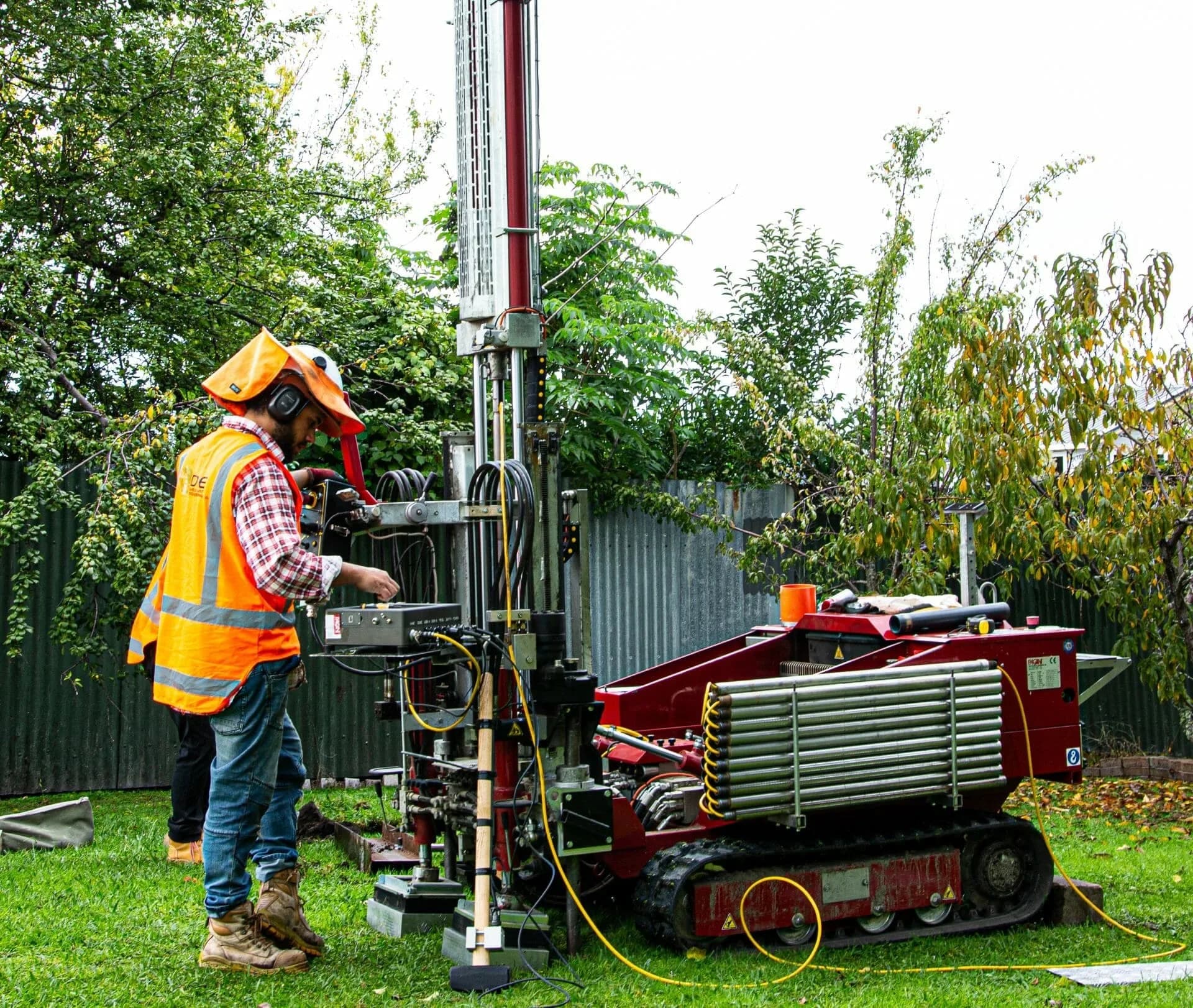 Explore Geotechnical operator running a tracked direct-push drilling rig in a suburban back garden, too tight for a conventional rig