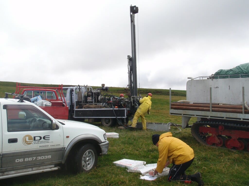 people working on investigations in a field with equipment.