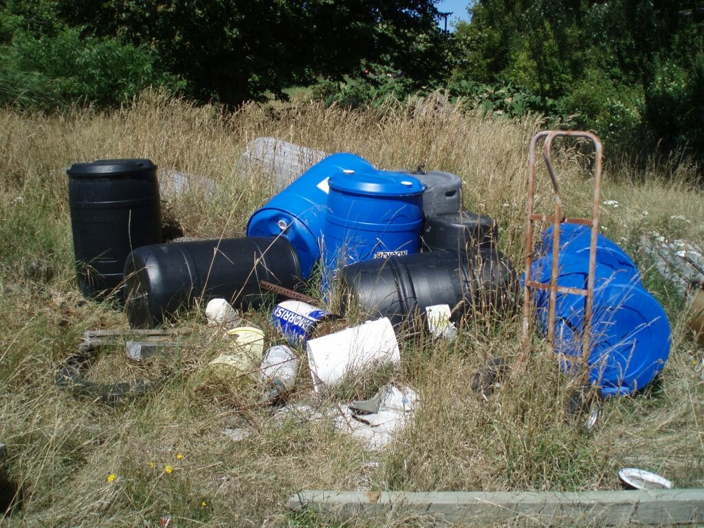 empty contaminated barrels lying on grass