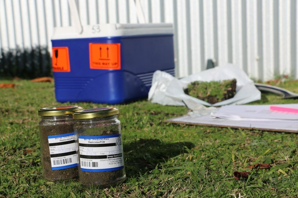 Jars of soil for contamination testing next to a blue cooler