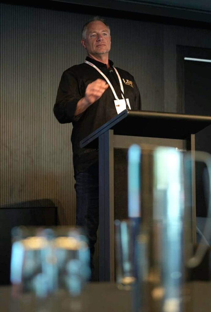 a man standing at a conference podium