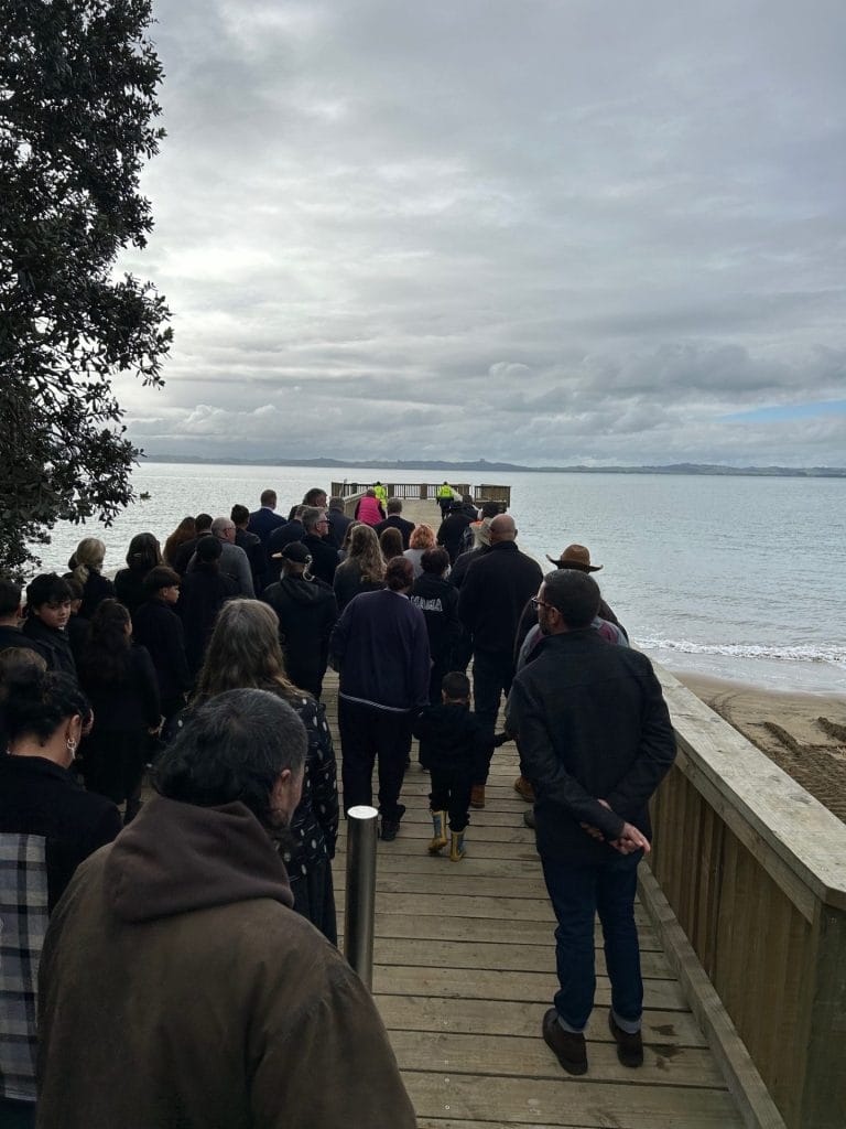 A group of people walking on a timber wharf