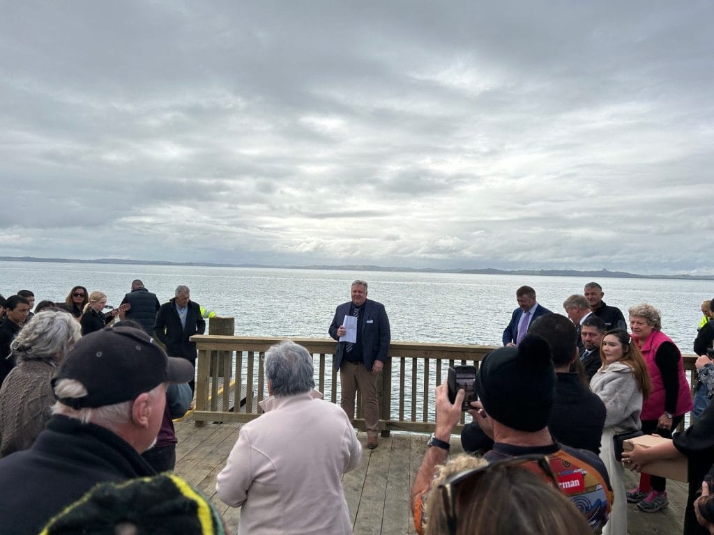 a group of people standing on a timber wharf